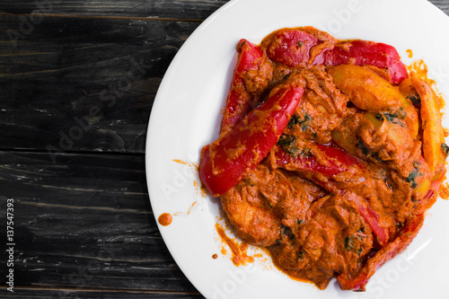 Bigus with chicken breast and bell pepper on a wooden table in rustic style