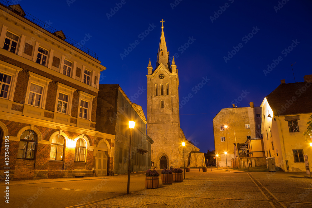 Medieval church of Saint John and night old town view of Cesis, Latvia.