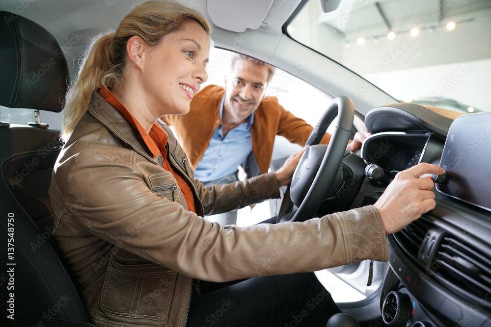 Woman sitting inside vehicle in car dealership Woman sitting inside vehicle in car dealership