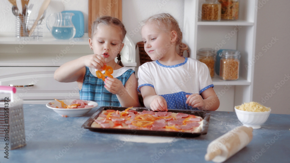 Little girls preparing pizza from ingredients Little girls preparing pizza from ingredients