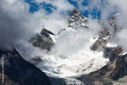 Paragliding in the Swiss Alps on a background of blue sky photo