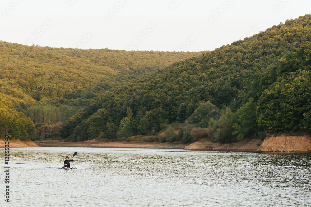 Woman sculling in the middle of the lake.