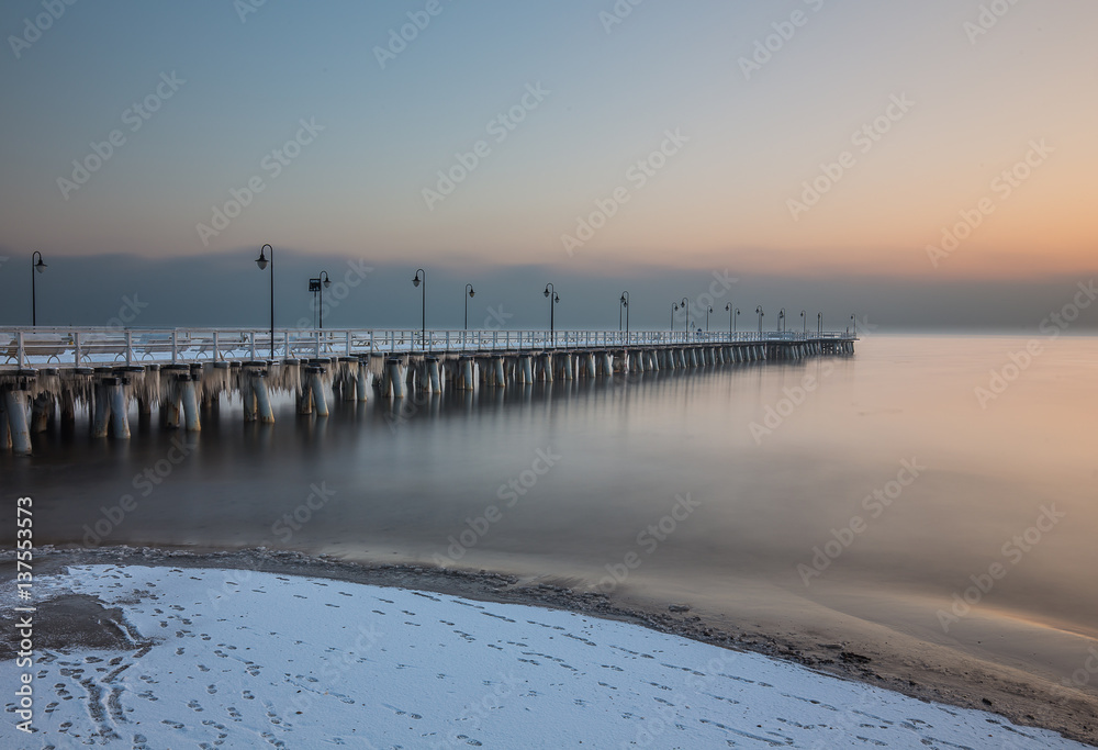 Winter scenery. Old pier in Gdynia Orlowo Poland with ice formations icicles. Frozen Sea Baltic seasonal specific.