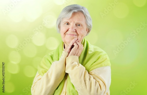 Senior happy woman on green background.