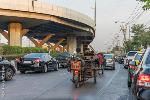 Tricycle and Car at intersection traffic light photo