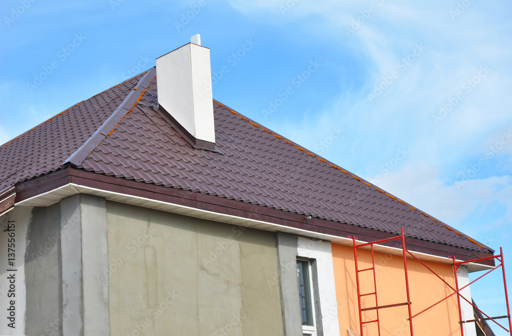 Metal roof construction with chimney installation, stucco, plastering and painting house wall. Metal Roofing Construction with Plastic Soffits.