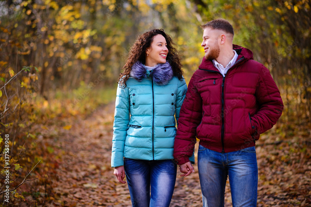 Lovers walking hand in hand in autumn park Lovers walking hand in hand in autumn park