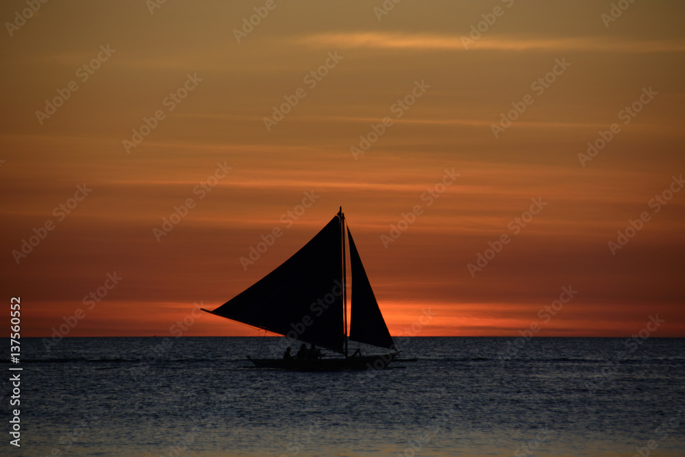 Lonely sailboat at sunset background over the sea in Boracay Island, Philippines