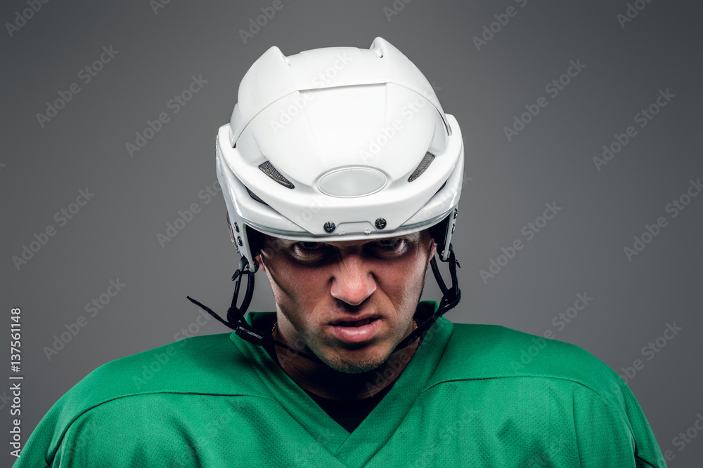 Naklejka premium Portrait of hockey player isolated on grey background.