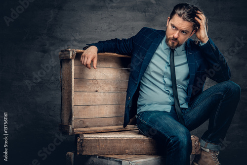 A man sits on a wooden box.