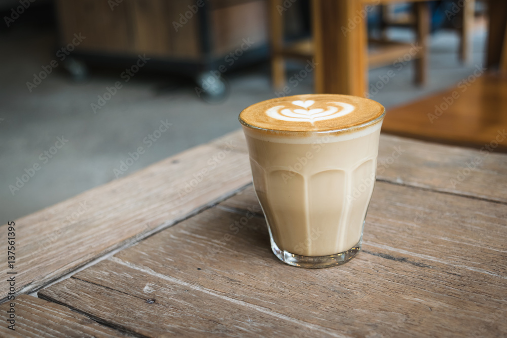 Hot glass of coffee on wooden table in the coffee shop. Hot glass of coffee on wooden table in the coffee shop.
