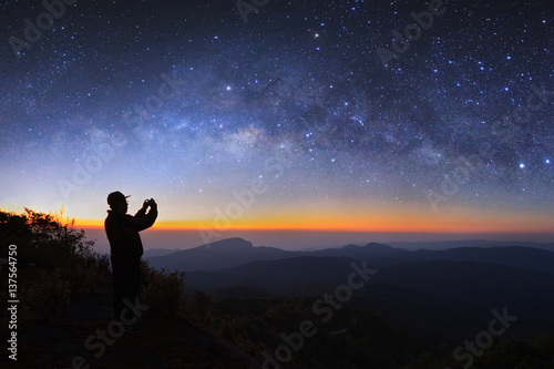 A man take photo milky way galaxy at Doi inthanon Chiang mai, Thailand. Long exposure photograph. With grain