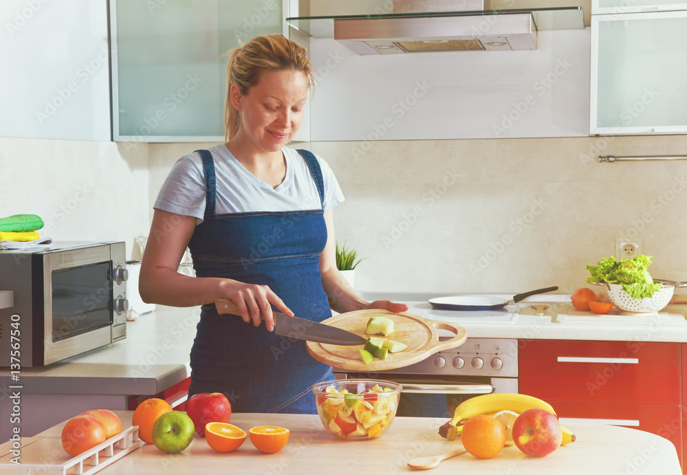 pregnant woman on kitchen making healthy fruit salad pregnant woman on kitchen making healthy fruit salad