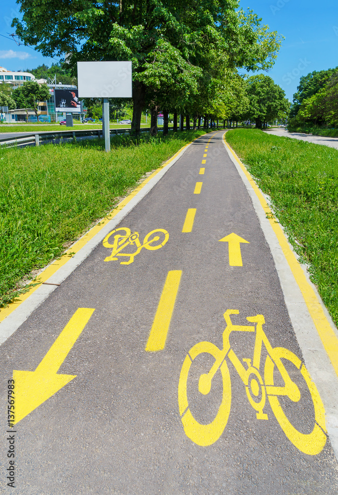 Obraz premium City landscape. Bicycle road in the city park. Sign showing bike path