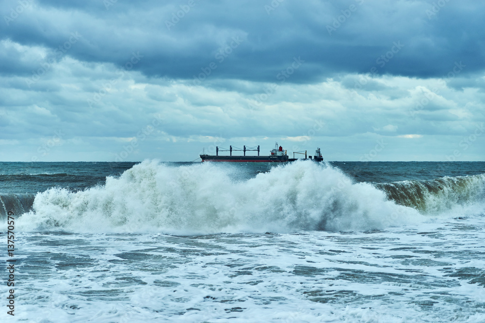 Sea view. Panorama of sea and sky. The storm and the storm clouds on the sea. Lonely cargo ship in the distance