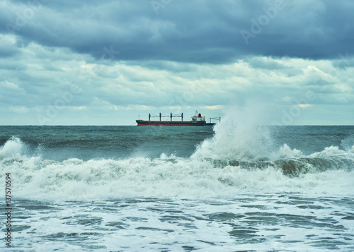 Sea view. Panorama of sea and sky. The storm and the storm clouds on the sea. Lonely cargo ship in the distance