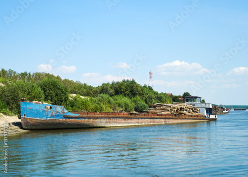 River landscape. The old cargo ship transporting the wood river