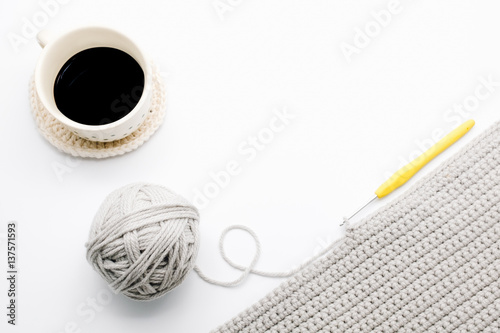 Workspace with crochet ball, crochet hook  and coffee, white background, desktop crochet handmade