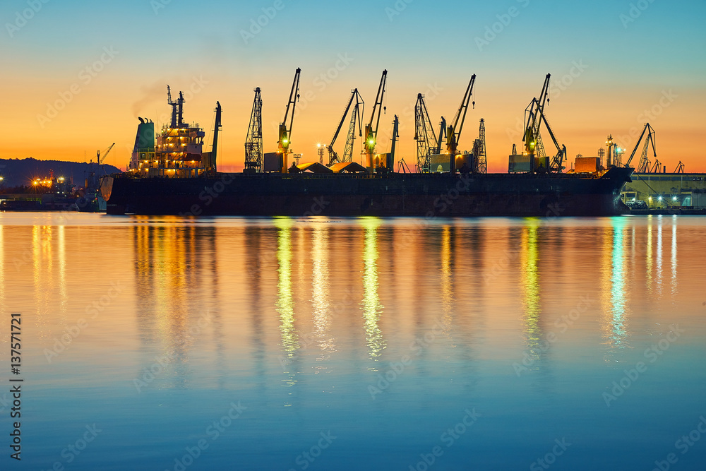 Evening panorama of the cargo port. Loading and unloading of ships
