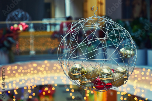 The scenery in the form of large and small balls in the lobby of a large modern shopping mall. Blurred background of lights garland 