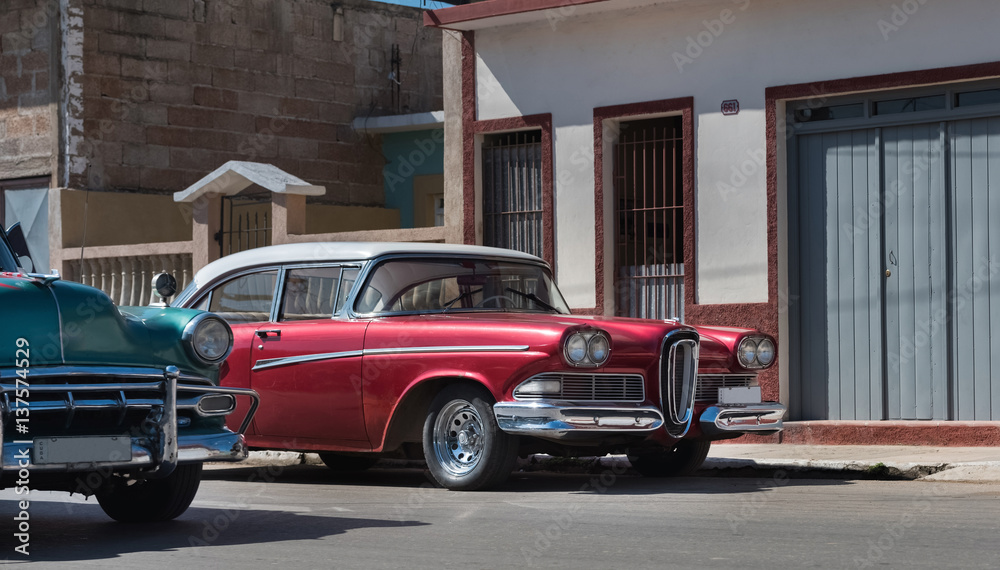 Amerikanischer roter Oldtimer parkt in der Seitenstrasse in Santiago de Cuba - Serie Kuba Reportage