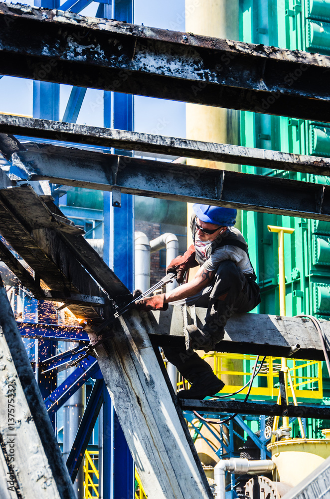 Cutting steel structure. Work at height. Man working on the demolition