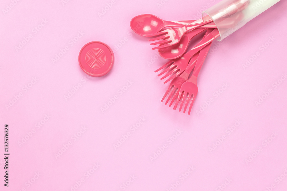 Top view colorful plastic spoon on pink table background with copy space.