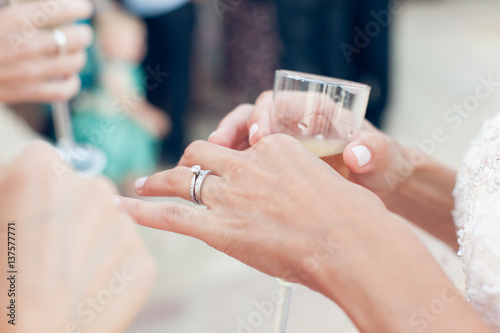 Bride with wedding ring holds a glass of champagne photo