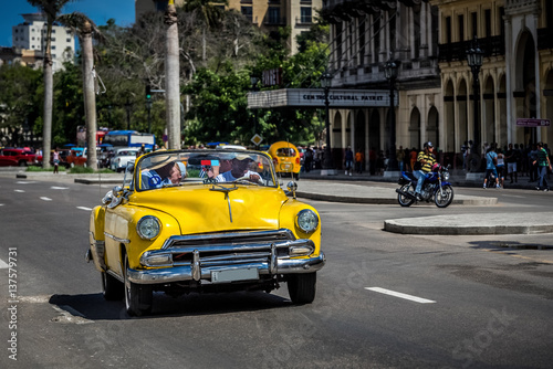 HDR - Auf der Hauptstrasse in Havanna Kuba fahrender amerikanischer gelber Cabriolet Oldtimer mit Touristen - Serie Kuba Reportage