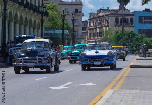 Amerikanische Oldtimer fahren auf der Hauptstrasse von Havanna City in Kuba - Serie Kuba Reportage