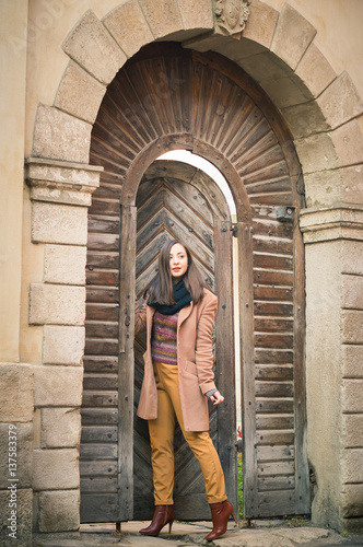 beautiful girl near old wooden gate in the city