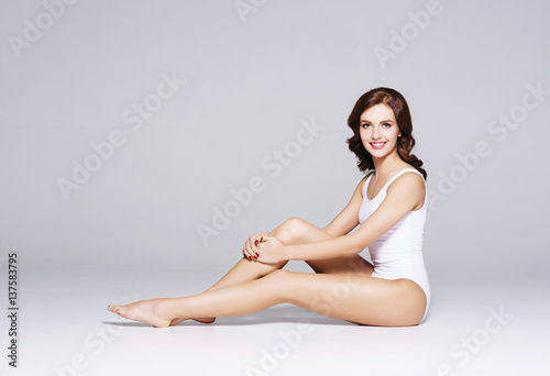 Fit and sporty girl in underwear. Beautiful and healthy woman posing over white background. Sport, fitness, diet, weight loss and healthcare concept.