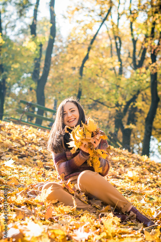 beautiful girl in autumn Park keeps yellow leaves