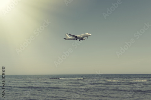 The plane landing over the sea at sunset in Cyprus