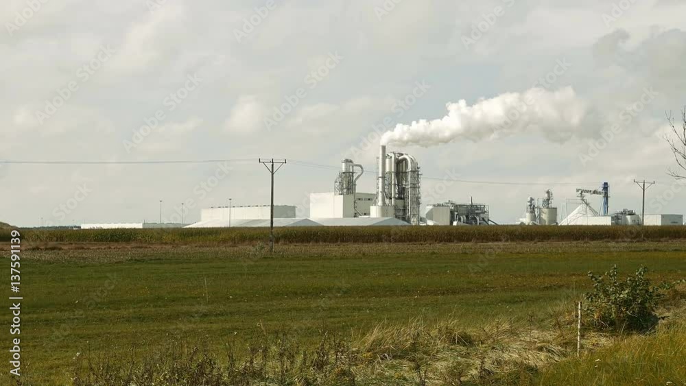 Factory smoke stack and pipes puff into air. Atmospheric air pollution industrial scene. Non-ecological and non-sustainable manufacturing pan shot. Factory smoke stack and pipes puff into air. Atmospheric air pollution industrial scene. Non-ecological and non-sustainable manufacturing pan shot.