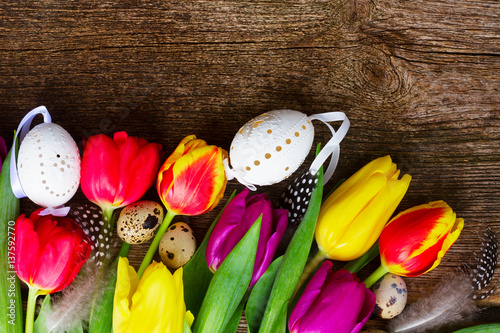 Spring fresh tulip flowers with easter eggs on wood photo