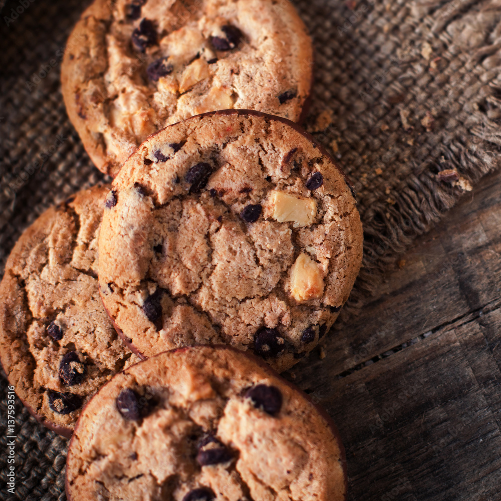 Chocolate cookies on dark napkin on wooden table. Closeup of a group of assorted cookies.. Chocolate cookies on dark napkin on wooden table. Closeup of a group of assorted cookies..