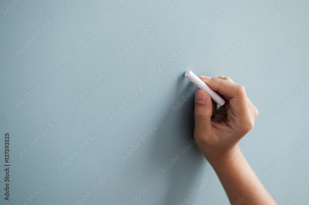 Woman hand drawing with white chalk on wall. Woman hand drawing with white chalk on wall.
