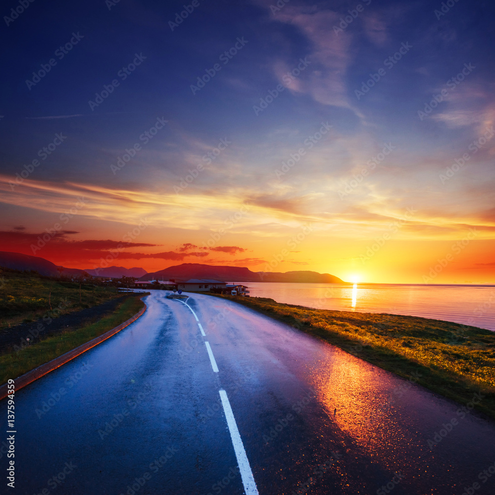 Φωτογραφία Asphalt road along the sea at sunset Iceland