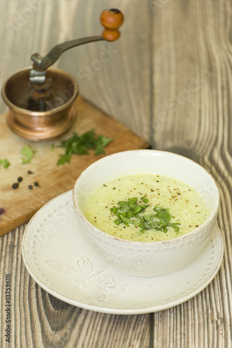 Kremowa zupa z czosnku, fasolki i cukinii w białej misce
