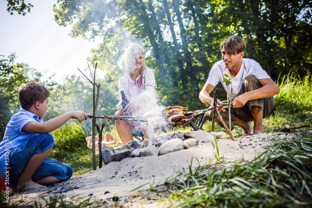 Family barbecuing on the riverside, foothills of the Alps, Bavaria, Germany Family barbecuing on the riverside, foothills of the Alps, Bavaria, Germany