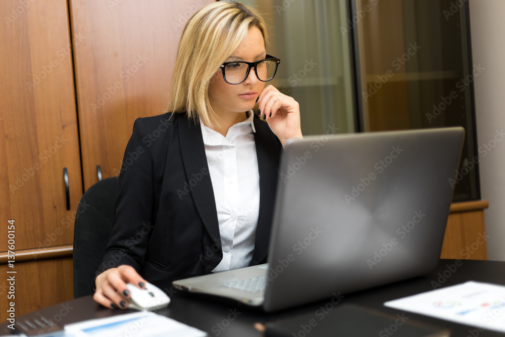 Portrait of a young smiling businesswoman using her computer Portrait of a young smiling businesswoman using her computer