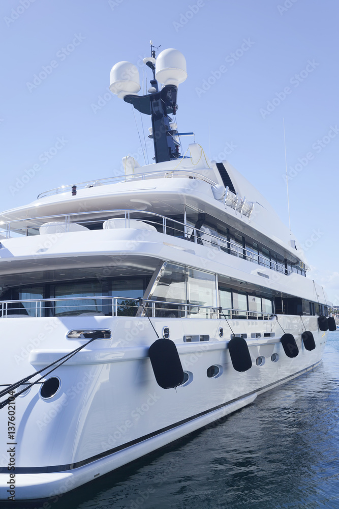 Naklejka premium Side of modern private luxury yacht anchored in a small sea port