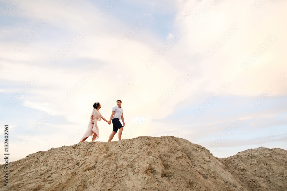 Honeymoon. Young couple walking on sand mountain Honeymoon. Young couple walking on sand mountain