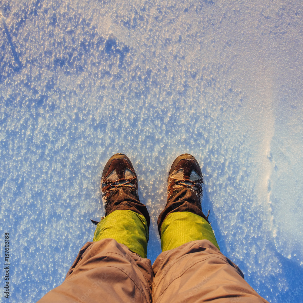 Tourist considering his shoes in the snow. Tourist considering his shoes in the snow.