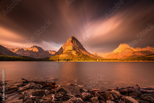 Sunrise in Glacier National Park. Long exposure with mount grinnell as a focal point at sunrise. clouds and smoke from forest fires created the dramatic effect photo