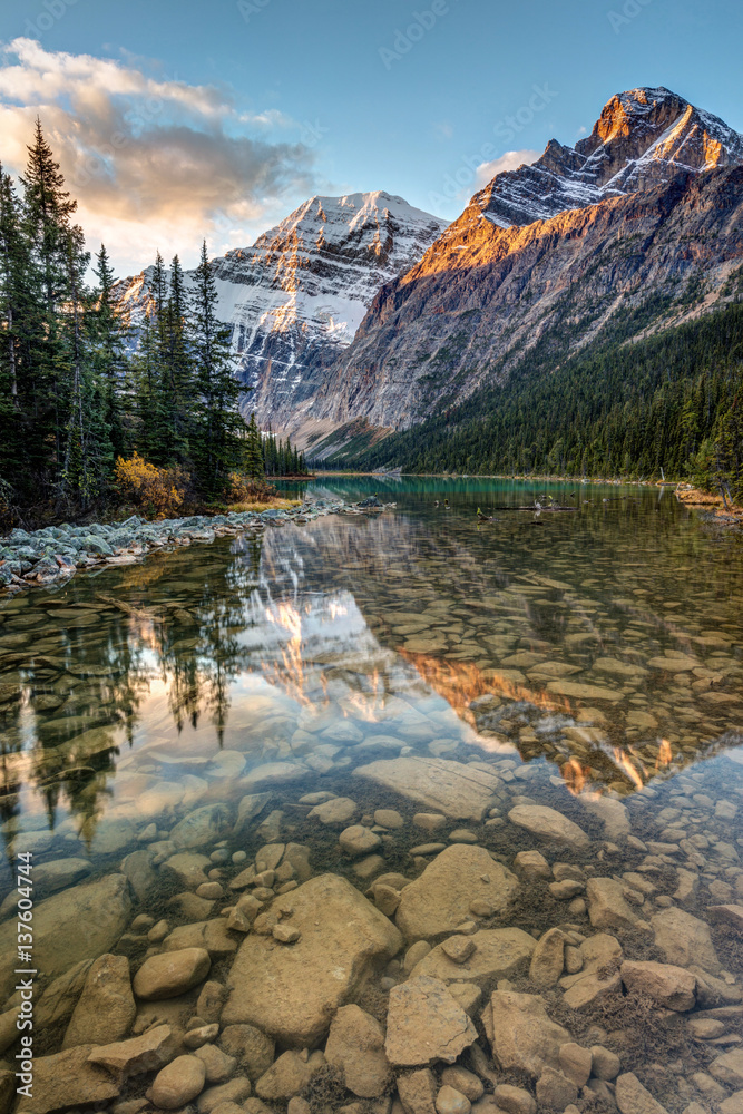 Mount Edith Cavell reflected in the calm river at sunrise in the rocky mountains of Jasper National Park, Alberta, Canada