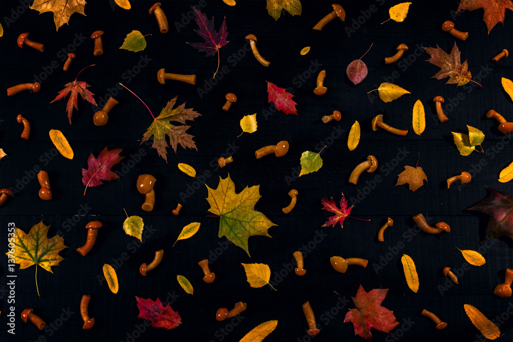 Background of autumn leaves and mushrooms on the black wooden table
