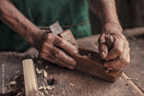 Senior carpenter in his workshop using wood plane, Karanac, Baranja, Croatia photo