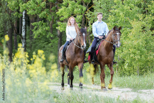 Young couple enjoying horseback riding. © Osetrik